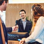 Cropped shot of a businessman and businesswoman checking into a hotel