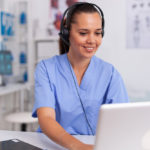 medical-staff-talking-with-patient-about-prescription-wearing-headset-with-microphone-in-hospital-office-health-care-physician-sitting-at-desk-using-computer-in-modern-clinic-looking-at-monitor